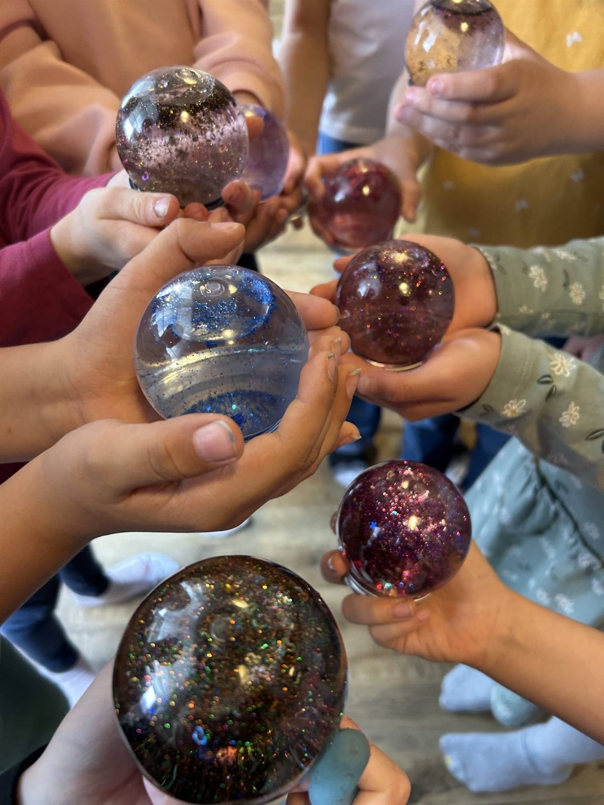 Kinderhände halten selbst gemachte Glitzerkugeln